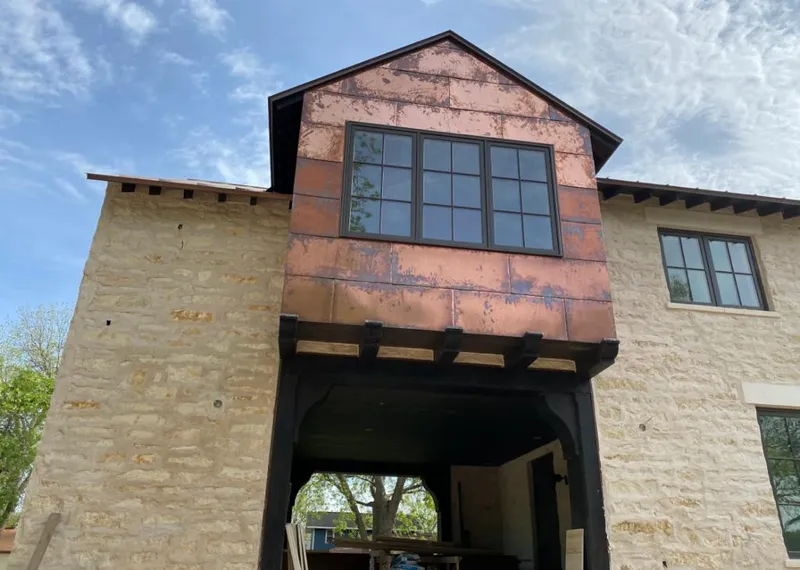 Copper metal panel facade on a stone building for Roof Repair in Rockport